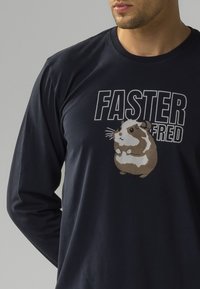 Granatowy T-shirt z długim rękawem, wykonany z bawełny, z graficznym nadrukiem chomika oraz napisem "FASTER FRED" w białym i czarnym kolorze.