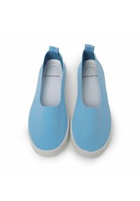 Zapatos de goma de color azul claro, tipo slip-on, con una textura suave, suelas blancas con un patrón texturizado y un diseño minimalista.