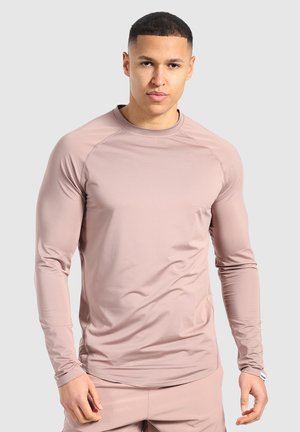 Langsleeve sportshirt van zacht stof in een stoffige rozenkleur, met een ronde halslijn, raglanmouwen en een gladde textuur.