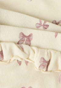 Marszczyty materiał w jasnym żółtym prążkowanym wzorze, z motywem motyli w stonowanych różowych odcieniach. Miękki, szczegółowy i warstwowy design.