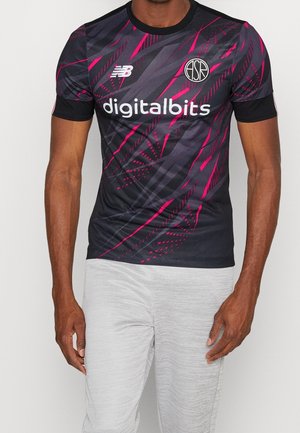 Mand iført mørk sportsjersey med lyserøde mønstre og "digitalbits" logo, kombineret med lysegrå bukser.