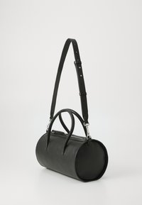 Black leather cylindrical bag with two top handles and a detachable adjustable strap. Features a zip closure and textured surface detailing.
