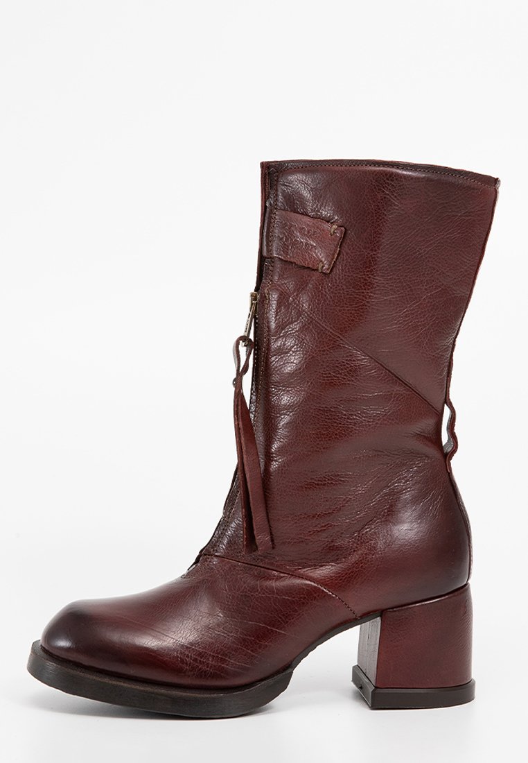 Bota de tobillo de cuero burdeos con un tacón grueso, cremallera lateral y detalles de costura. Presenta una superficie texturizada y un acento de correa lateral.