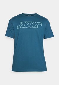 Türkisfarbiges T-Shirt mit kurzen Ärmeln aus weichem Material, das ein auffälliges weißes Grafikdesign auf der Brust zeigt. Runder Halsausschnitt und normale Passform.