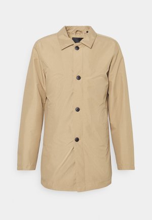 Chaqueta exterior beige hecha de una tela ligera, con cierre de botones en la parte delantera, cuello apuntado y mangas largas con un corte relajado.