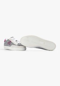 Sneakers z czarno-białym wzorem w kropki, różowymi akcentami, białymi sznurowadłami oraz teksturowaną kremową podeszwą w wzór rybiej ości.