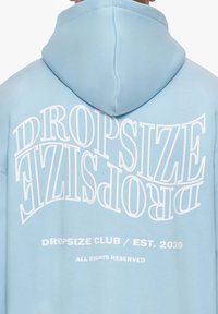 Svijetloplava dukserica s kapuljačom koja na leđima ima veliki, stilizirani bijeli natpis "DROPSIZE" i "DROPSIZE CLUB / EST. 2020."
