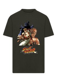 Black cotton t-shirt featuring colorful cartoon characters from Street Fighter. Design includes two fighters and logo at the bottom.