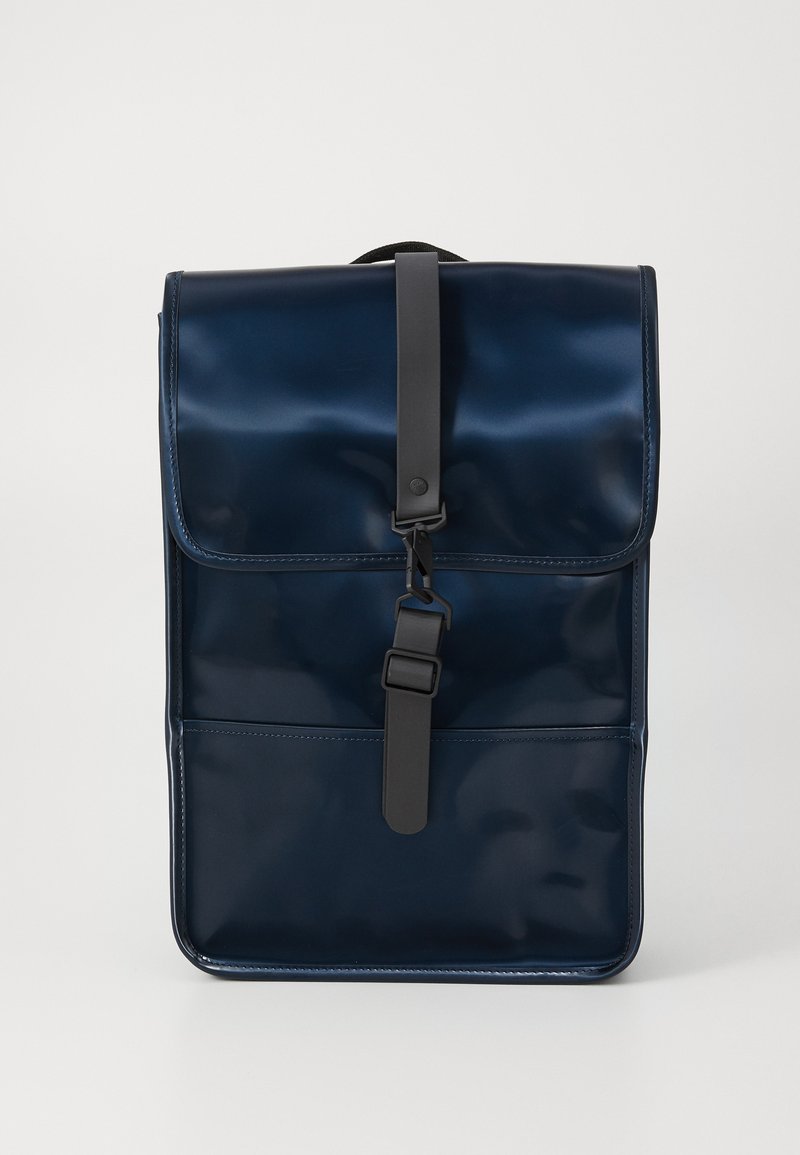 Mochila azul marino con acabado brillante, que presenta una correa negra y cierre de hebilla, contra un fondo blanco liso.