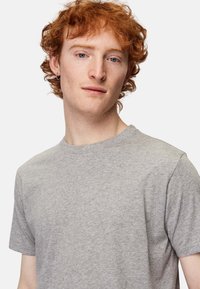 Grå kortærmet t-shirt lavet af blødt bomuld. Klassisk crew neck-design med en glat overflade og uden synlige mønstre eller logoer.
