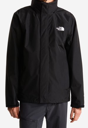 Zwarte waterdichte jas met hoge kraag en ritssluiting aan de voorkant, gedragen door een persoon, met het The North Face-logo op de borst.