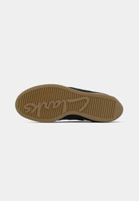 Shoe sole with brown rubber tread featuring horizontal grooves and "Clarks" logo embossed diagonally across the bottom.