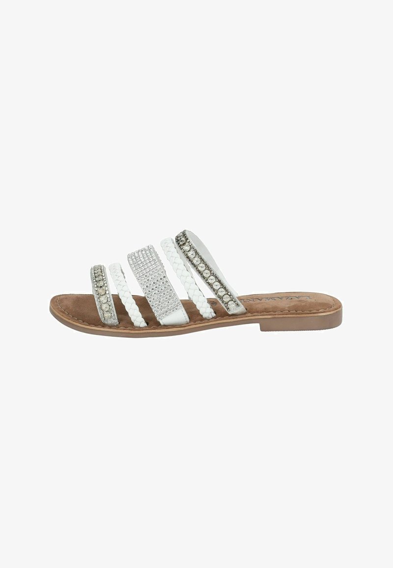Witte slide sandalen hebben vier banden: twee gevlochten, eentje versierd met zilveren studs en de vierde met heldere schouderstenen. Bruine binnenzool.