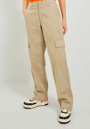 Beiga cargo-byxor tillverkade av bomull, med två sidofickor, en avslappnad passform och stiliserade med svarta och vita sneakers.