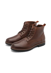 Botas de cuero marrón hasta el tobillo con un acabado texturizado, diseño con cordones y punta redonda. Suela de goma negra resistente con un ligero patrón de relieve.