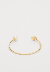 Bracelete de pulso metálico dourado com uma única pérola redonda em uma extremidade e um detalhe floral no lado oposto. Textura suave, design minimalista.