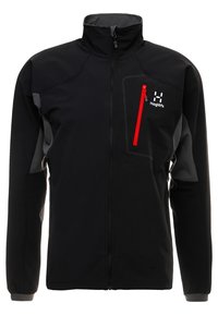 Svart softshelljacka med grå detaljer, hög krage, hel dragkedja och en röd dragkedjeförsedd bröstficka. Har en logotyp på vänster sida.