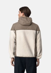 Giacca in pile e nylon con cappuccio marrone e sezione superiore, caratterizzata da una parte bassa e maniche in pile bianco testurizzato, progettata per il calore.