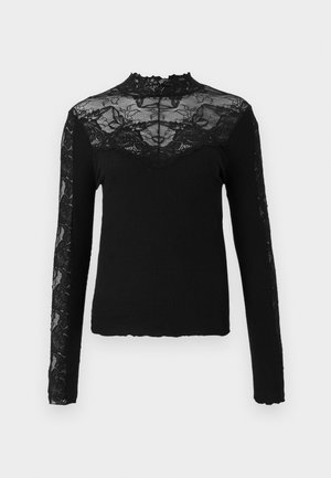 Top preto de mangas longas com corpo canelado e detalhes em renda transparente nos ombros, gola e mangas, apresentando uma gola com borda ondulada.