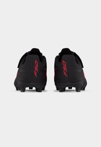 Ζευγάρι μαύρα παπούτσια ποδοσφαίρου με κόκκινη σήμανση "F50" στη φτέρνα, ορατά από πίσω, εμφανίζοντας τα καρφιά στη σόλα.