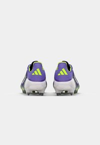 Purple cleats with lime green accents, featuring a textured upper, molded heel, and translucent sole. Three stripes logo visible.