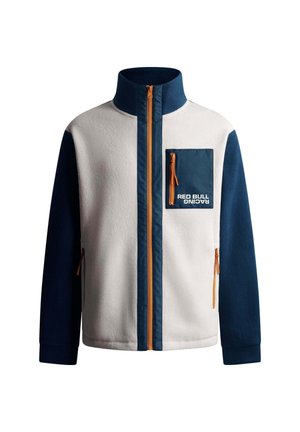 Fleecejack in wit en marineblauw met een hoge kraag, oranje rits en een borstzak met een rits en het logo "RED BULL RACING".