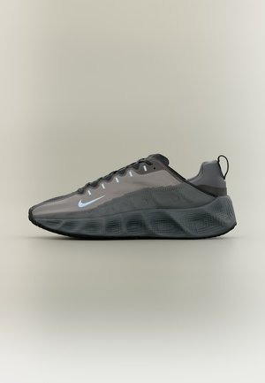 Niedriger grauer und schwarzer Sportschuh mit transparentem Obermaterial, Schnürdesign, dicker strukturierter Sohle und weißem Nike Swoosh-Logo.