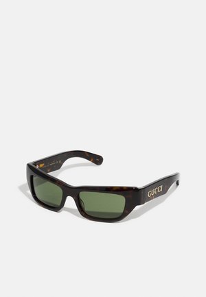 Occhiali da sole tartarugati con lenti verdi. Design della montatura quadrata, con logo dorato sulla tempia. Finitura in plastica liscia.