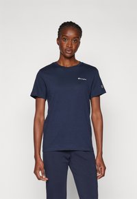 Marineblauwe katoenen t-shirt met korte mouwen, ronde halslijn en een klein logo op de borst. Gerekend met bijpassende marineblauwe onderkleding.