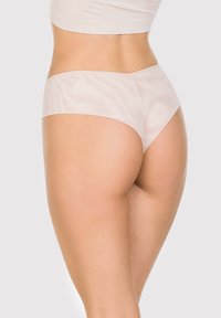 Jasnopomarańczowe, bezszwowe majtki o gładkiej, miękkiej fakturze i nowoczesnym kroju, z minimalistycznym designem i brakiem widocznych elementów metalowych.