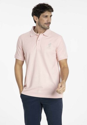 Polo rose clair avec un col classique, des manches courtes et un logo brodé sur la poitrine, fabriqué en tissu en coton respirant.