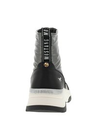 Baskets montantes noires et grises avec une semelle texturée, une tige élastique et une sangle avec logo proéminente à l'arrière. Détail en accent doré inclus.