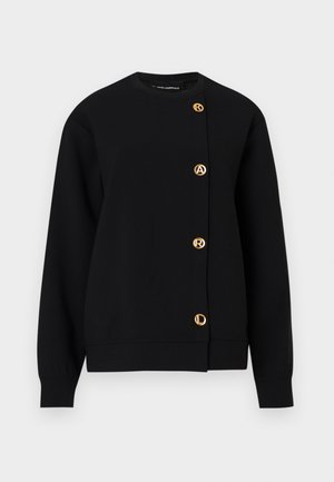 Juodas džemperis, pagamintas iš minkštos medžiagos, su apvaliu iškirpimu, ilgomis rankovėmis ir auksinės spalvos logotipo mygtukais priekyje.