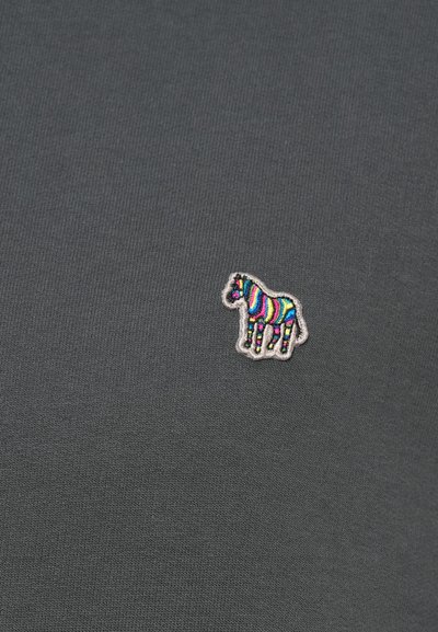 Tamsiai pilkas audinys su nedideliu siuvinėtu zebro paveikslėliu, kuris turi ryškius vaivorykštės atspalvius, esančiais arti centro.