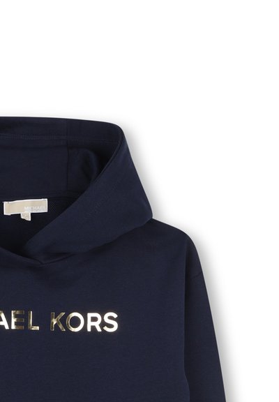 Mornarska kapuca z metalik zlatim logotipom "MICHAEL KORS", ki ima vrvico za zategovanje in mehak material, primerna za vsakodnevno nošenje.