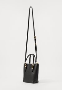 Sac à main en cuir noir texturé avec deux anses courtes et une longue sangle ajustable. Accents en métal doré avec un design minimaliste.