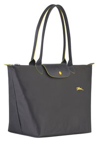 Sac fourre-tout gris foncé avec des accents jaunes, en matériau synthétique texturé, fermeture zippée et deux longues poignées. Présente un logo à l'avant.