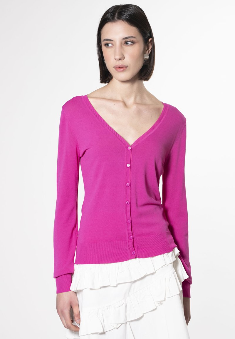 Cardigan fucsia a maniche lunghe realizzato in morbido tessuto a maglia. Presenta un profondo scollo a V e sei bottoni abbinati lungo la parte anteriore.