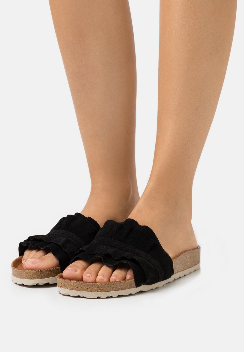 Zwarte slide-sandalen met een bovenwerk van gerimpeld stof, een kurken voetbed en een gestructureerde rubberen zool. Open teen ontwerp voor comfort en ademend vermogen.