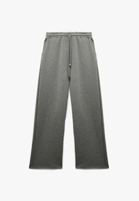 Grå sweatpants i ett mjukt, strukturerat tyg med elastisk midjeband och snörning. Har sidfickor och en avslappnad passform.