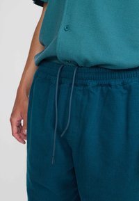 Teal katoenmix shirt met een textuurpatroon, knopsluiting, gecombineerd met bijpassende teal joggers met trekkoord en ribgebreide manchetten.