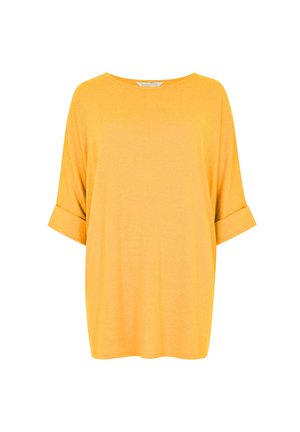 T-shirt gialla oversize con maniche corte arrotolate e scollatura rotonda. Realizzata in tessuto morbido con una consistenza liscia.