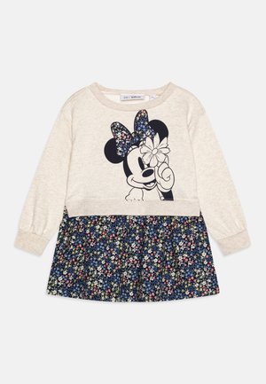 Robe à manches longues couleur crème avec un visage de Minnie Mouse noir tenant une fleur, et une jupe à motif floral bleu marine.