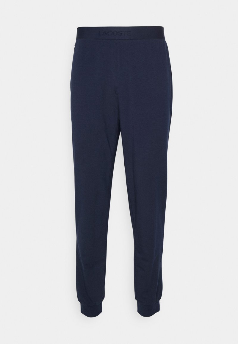 Pantaloni jogger navy in tessuto morbido, dotati di una vita elasticizzata con marchio embossato e polsini aderenti. Design semplice e snello.