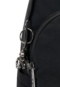 Sac à dos en tissu noir doté d'un porte-clés métallique au design de robot, d'une poche zippée et de coutures le long des bords.