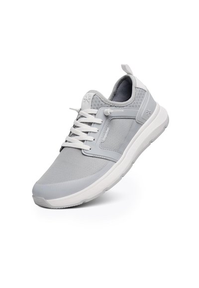 Scarpa sportiva grigia chiara in materiali mesh e sintetici, con lacci, collare imbottito e suola in gomma bianca, dotata di un tallone rinforzato.