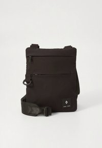 Crna torba na rame od teksturirane tkanine. Ima podesive remene, prednji džep na patentni zatvarač i logotip na donjem desnom kutu.