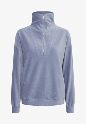 Sudadera de color azul claro, con cremallera y cuello alto. Presenta un tejido texturizado y un escote en V con detalles de costura. Mangas de corte holgado.