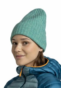 Light teal ribbed knit beanie with a pointed top, worn with a blue puffer jacket featuring an orange zipper accent. Soft texture and snug fit.