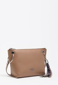 Beżowa skórzana torebka z zamkiem błyskawicznym, srebrnymi okuciami i ozdobnym chwostem. Charakteryzuje się czystym, prostokątnym kształtem.